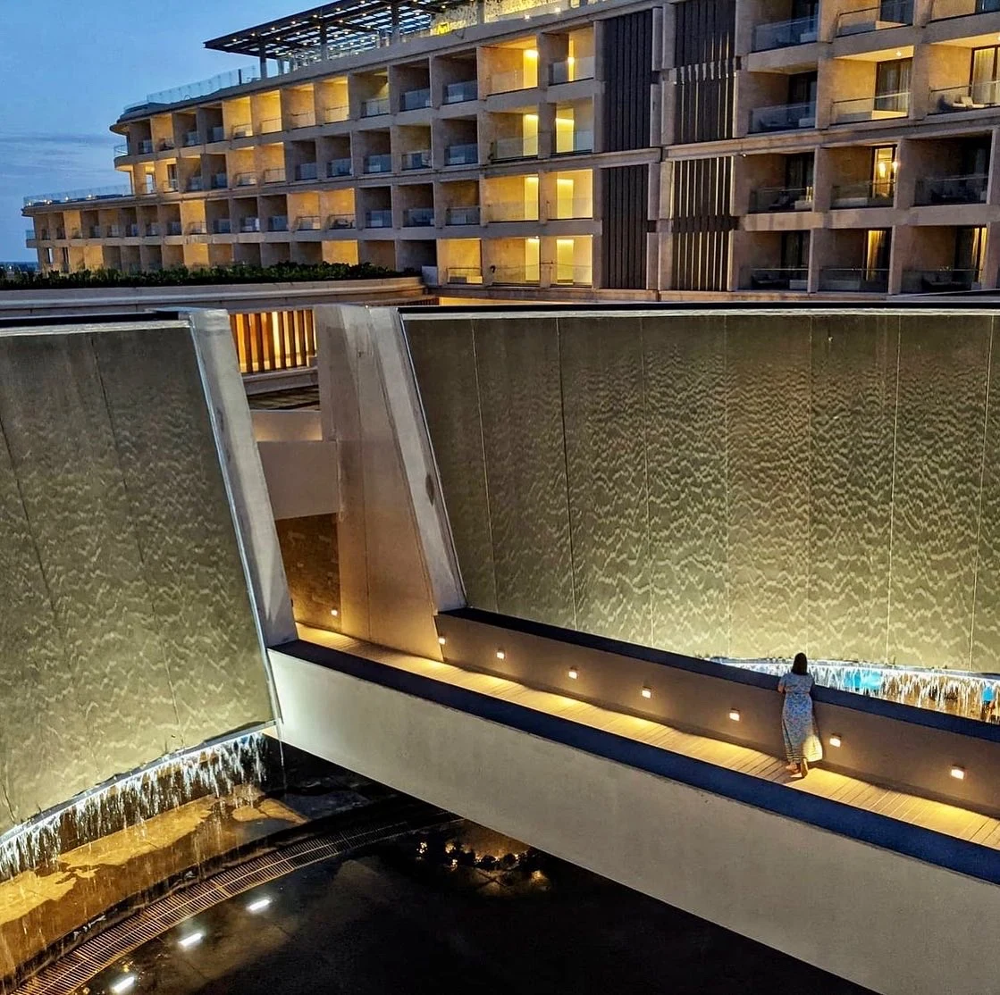 Caída de agua del tronco cónico hacia el spa e iluminación nocturna